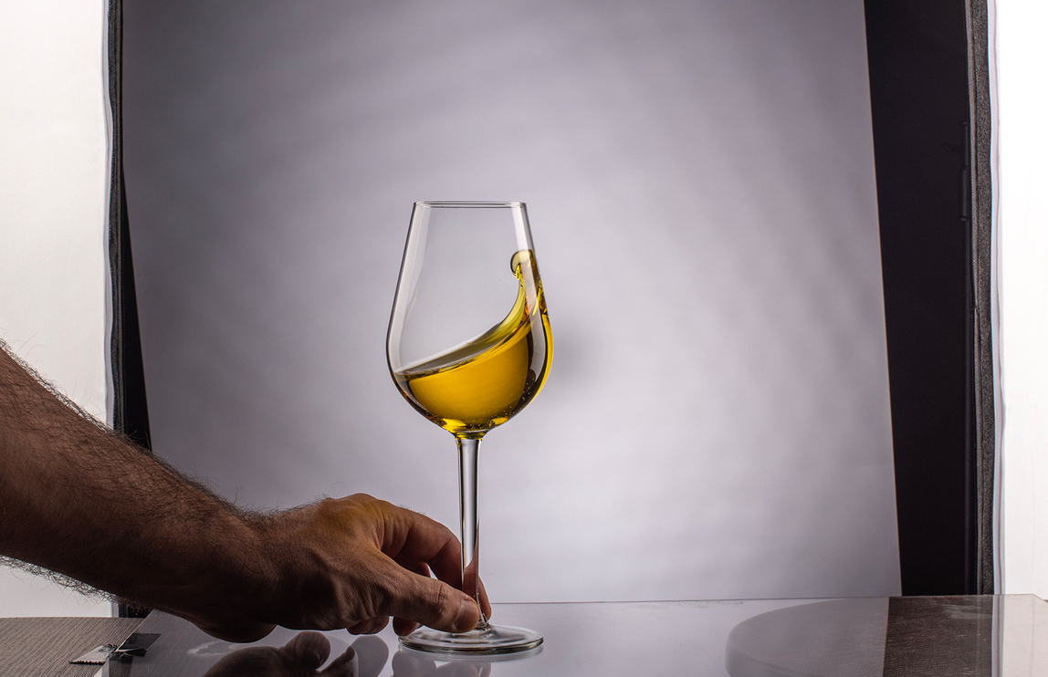 Backstage in photography studio with hand holding wine glass Hand holding a glass of wine in a photography studio